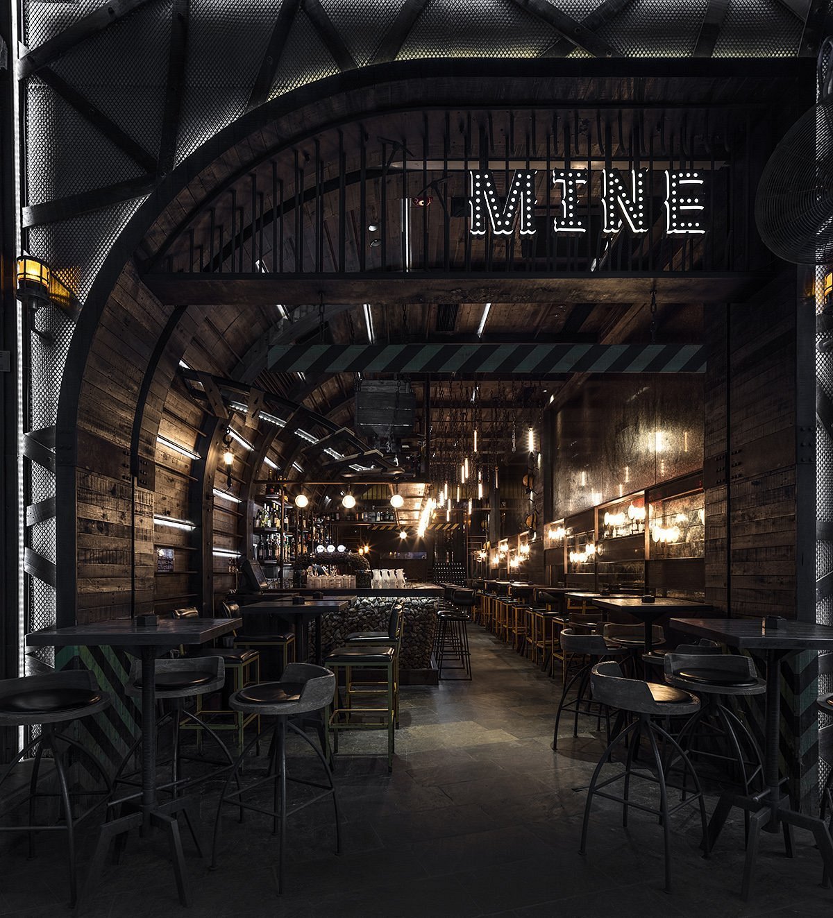 MINE Lan Kwai Fong interior — a coal-mine themed cocktail bar with arched brick tunnels, hanging filament lights and a glowing MINE sign over the bar